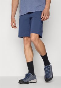 Navy shorts made of lightweight fabric, featuring a straight cut. Paired with dark socks and gray hiking shoes with black accents.
