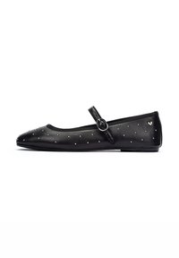 Bailarinas de cuero negro con punta redondeada, una correa estrecha con una hebilla plateada y tachuelas decorativas en la parte superior.