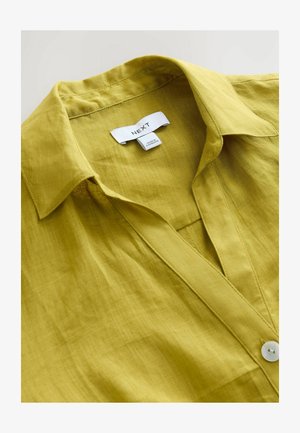 Limoengroene overhemd met kraag, gemaakt van lichtgewicht stof, met een knoopsluiting aan de voorkant en een subtiele textuur. Etiket zichtbaar binnenin de kraag.