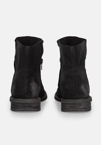 Botas de tobillo de ante negro con una textura rugosa, tacón bajo apilado y cierre de cremallera en el lateral. Presentan un diseño simple y limpio.