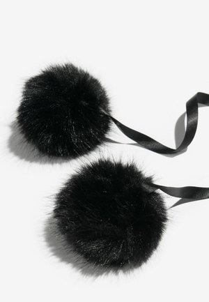 Crni pomponi od umjetnog krzna pričvršćeni crnim satenastim trakama. Svaki pompon je pahuljast i okrugao, s mekanom, teksturiranom površinom.