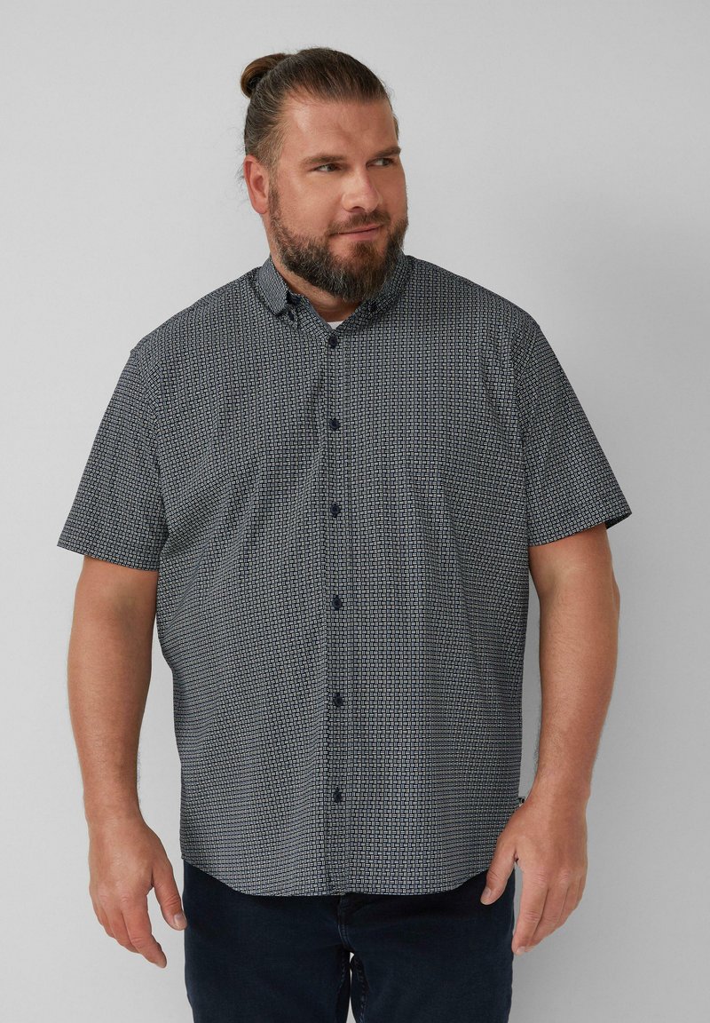 Korte mouwen, knoopshirt in marineblauw met een geometrisch wit patroon. Heeft een kraag en donkere knopen. Zacht materiaal met een casual pasvorm.
