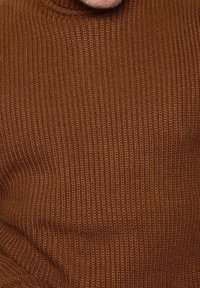 Pull en maille côtelée marron avec un col haut. La texture est douce et épaisse, présentant un motif uniforme sur l'ensemble.