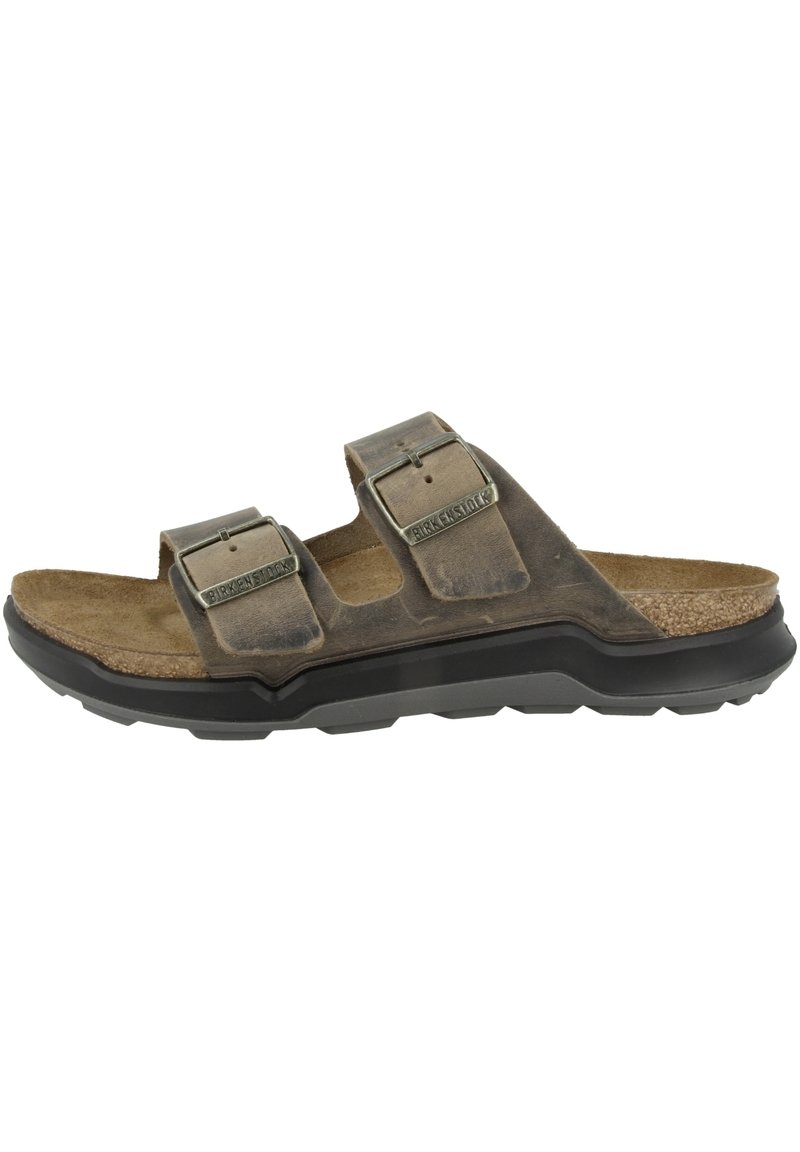 Sandali in pelle marrone con due fibbie regolabili, soletta in sughero e una suola nera in gomma robusta, con una superficie testurizzata.