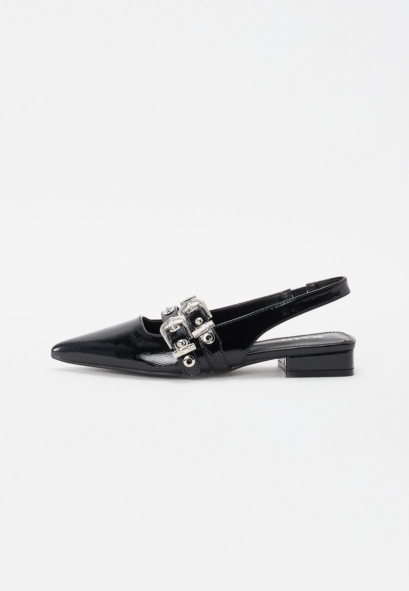 Zapato negro de tacón bajo con punta afilada y acabado en charol brillante, que presenta detalles en hebilla plateada y un tacón bajo.