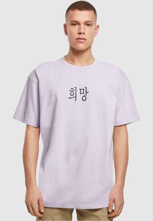 Lavender cotton t-shirt featuring black text with Korean characters in the center. Short sleeves and a relaxed fit.