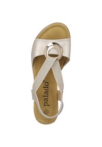 Sandali Palado con tomaia in pelle beige, accento circolare metallico, cinturini testurizzati e soletta imbottita. Presentano un design con cinturini incrociati.