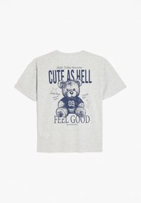 Camiseta de algodón gris con un diseño impreso de oso de peluche en azul marino, con el texto "CUTE AS HELL" y "FEEL GOOD" en fuentes llamativas y divertidas.