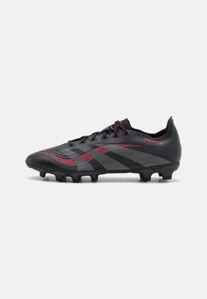 Black soccer cleat with red accents, textured synthetic upper, lace-up design, and molded studs for traction on grass surfaces.