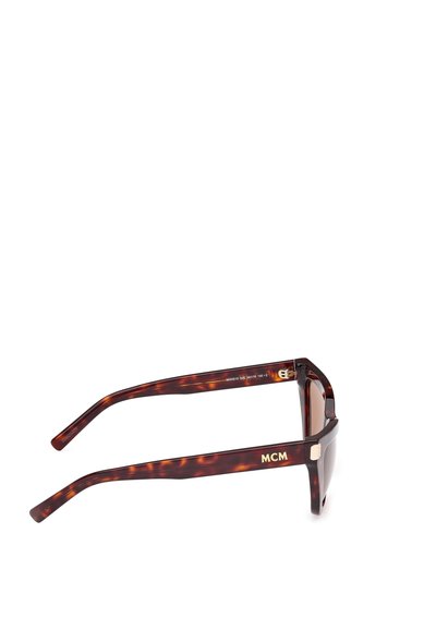 Ochelari de soare cu rame din material cu model țestoasă, cu lentile dreptunghiulare, având brandul „MCM” de culoare aurie pe brate și un finisaj lucios.