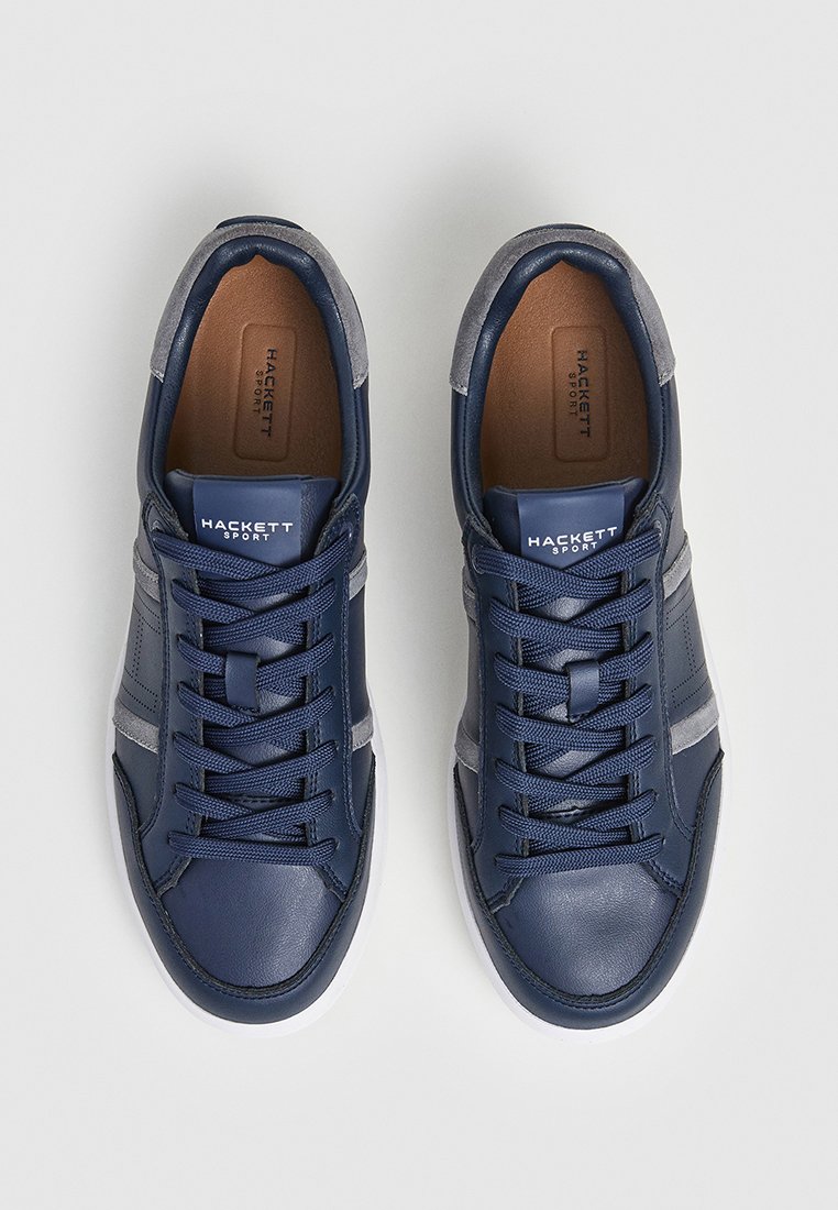 Baskets en cuir navy avec accents gris, lacets plats et semelle intérieure beige. Présentent une semelle en caoutchouc blanche et un logo sur la languette.