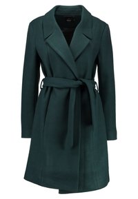 Mørkegrøn knælang frakk for kvinder med brede revers og et stofbælte knyttet i taljen, præsenteret på en hvid baggrund.
