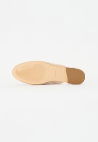 Talpa de pantof în nuanță bej, cu un model texturat pentru aderență. Marca "GUESS" embosată aproape de călcâi. Formă rotundă și design cu margini netede.