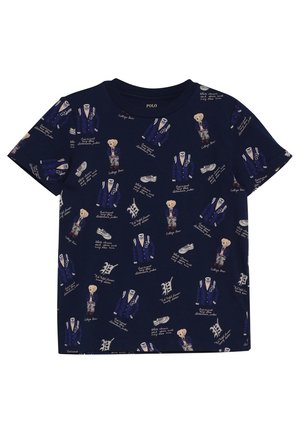 Camiseta de algodón navy con estampados repetidos de un oso con chaqueta de varsity, zapatillas y acentos de texto. Cuello redondo, mangas cortas.