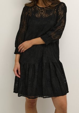 Schwarzes Spitzenkleid mit 3/4-Ärmeln, Blumenmustern, einem gestuften Rock und gerafften Bündchen. Textiles Material verleiht dem Design Tiefe.