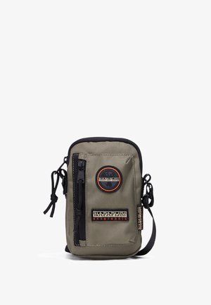 Oliveově zelený látkový sáček s černými akcenty, se zipovým uzávěrem a nastavitelným páskem. Obsahuje nášivky s logem a přední zipovou kapsu. Kompaktní design.