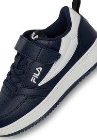 Sneaker blu navy con tomaia in pelle texturizzata, dettagli bianchi, chiusura con lacci e strap in velcro, suola in gomma con motivo a battistrada.
