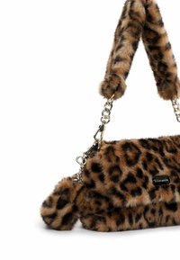 Tasche aus faulem Leopardenfell mit einer Kettenhandle, plüschiger Textur, runder Form und einem abnehmbaren Pom-Pom-Akzent. Details aus silbernem Metall.
