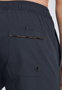 Shorts marine avec une taille élastique, une poche arrière avec un détail de couture et un bouton noir pour plus de fonctionnalité.