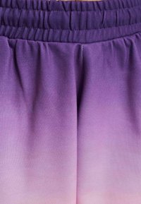 Pantaloni corti ombrè viola con elastico in vita. Il tessuto è liscio e morbido, che passa da un viola intenso a una lavanda chiara all'orlo.