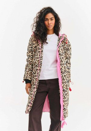 Kurtka puchowa w wzór panterki z różowym zamkiem i detalami w postaci troczków, z długimi rękawami i długością do kolan, noszona na białej koszuli.