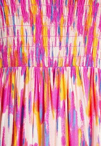 Pestrá látka na šaty s nařaseným vrškem. Obsahuje abstraktní vzory v růžové, žluté a modré barvě. Měkká textura s nahrnutými sklady.