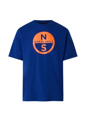 Camiseta azul de manga corta y cuello redondo con un gran logo circular naranja que dice "N NORTH SAILS" en el pecho.