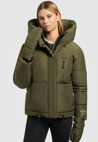 Oliivroheline puffer-jakk suure kapuutsiga, lukuga taskud ja elastsed nöörid. Omab tikandiga disaini ja paksu, polsterdatud varrukaid.