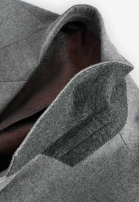 Grijze wollen blazer met een gestructureerde buitenstof, voorzien van een gladde bordeauxsatijnen voering en een ingewikkeld ruitpatroon aan de binnenzijde.