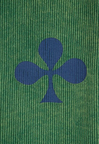 Tapete texturizado verde con un gran diseño de trébol de cuatro hojas en azul marino. La superficie tiene patrones de ribete vertical para mayor textura.