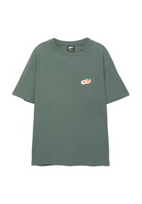 Grünes Baumwoll-T-Shirt mit entspannter Passform, das ein kleines gesticktes Design von einem Pfirsich und einem Blatt auf der Brust zeigt. Kurzarm und runder Ausschnitt.