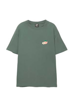 Zelené bavlnené tričko s voľným strihom, s malým vyšívaným motívom broskyne a listu na hrudi. Krátke rukávy a okrúhly výstrih.