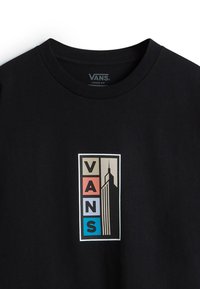 Black cotton t-shirt featuring a rectangular graphic with the word "VANS" and an illustration of a tower, accented in beige, red, and blue.