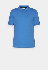 Polo bleu en tissu lisse. Doté d'un col classique et d'une patte de boutonnage à trois boutons. Petit logo noir sur la poitrine.