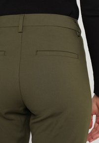 Olivgröna skräddarsydda byxor med en slät yta, med två bakfickor och rak skärning vid midjan för en snygg finish.