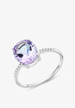 Srebrn prsten s velikim svijetlopurpurnim kamenjem jastučićastog reza i malim dijamantima ugrađenim duž gornje polovice prstena.