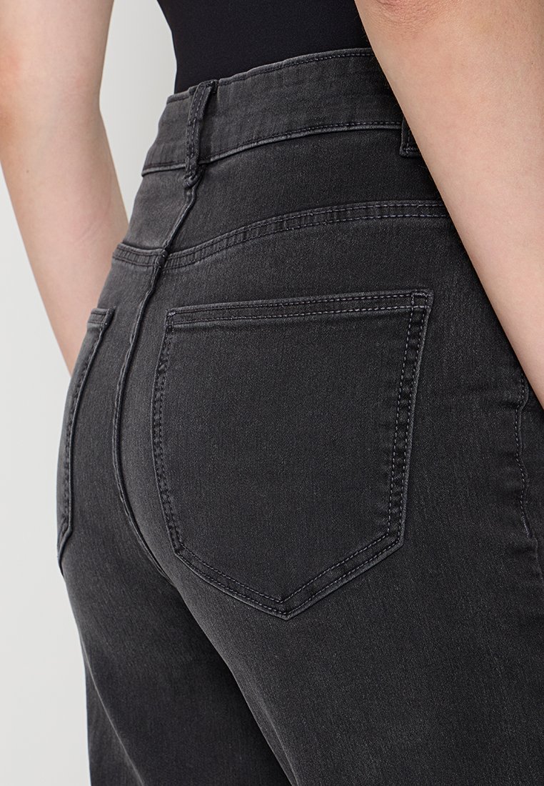Donkergrijze denim jeans met een aangesloten ontwerp, met een hoge taille, achterzakken en subtiele stiksels. Zachte textuur en een gladde afwerking.