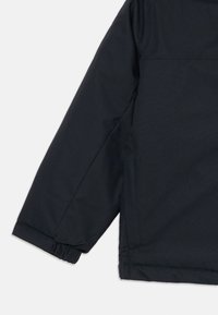 Schwarzer Jackenärmel mit elastischem Bund und Seitentasche, vor einem schlichten weißen Hintergrund.