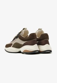 Braune und beige Sport-Schuhe aus einer Mischung aus strukturiertem Stoff und Wildleder. Runde Zehenpartie, gepolsterter Kragen und eine robuste Sohle mit einer schwarzen Laufsohle.