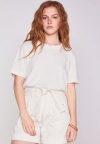 Witte katoenen t-shirt met korte mouwen, gecombineerd met hoge witte shorts met een riem, met een soepele textuur en een casual ontwerp.