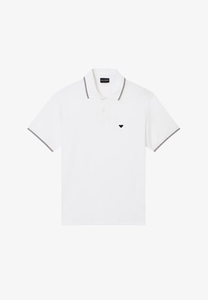 Polo bianca a maniche corte con colletto e bordi delle maniche a righe nere e bianche, con un piccolo logo nero sul petto.