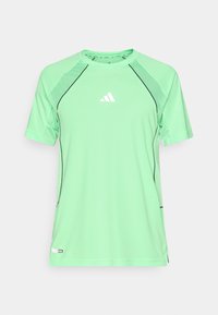 Green athletic shirt made of lightweight fabric. Features black stitching, short sleeves, and a small white logo on the chest.