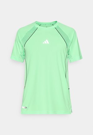 Cămașă sportivă verde, realizată din țesătură ușoară. Are cusături negre, mâneci scurte și un mic logo alb pe piept.