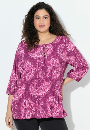 Violetti paisley-kuvioinen blouse, jossa on pyöreä kaula-aukko, laskostettu pinta ja solmiyksityiskohta edessä. Kolme neljännestä hihaa ja rento malli.