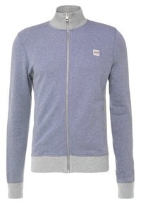 Giacca da uomo con zip di colore blu, con colletto, polsini e orlo grigi chiari, caratterizzata da una piccola patch del logo "BOSS" sul lato sinistro del petto.