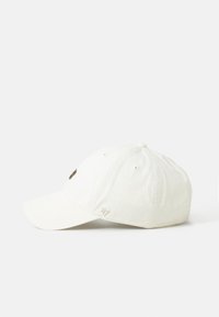 Casquette de baseball blanc cassé avec visière incurvée, petit logo brodé près de la visière et œillets de ventilation sur les panneaux supérieurs.