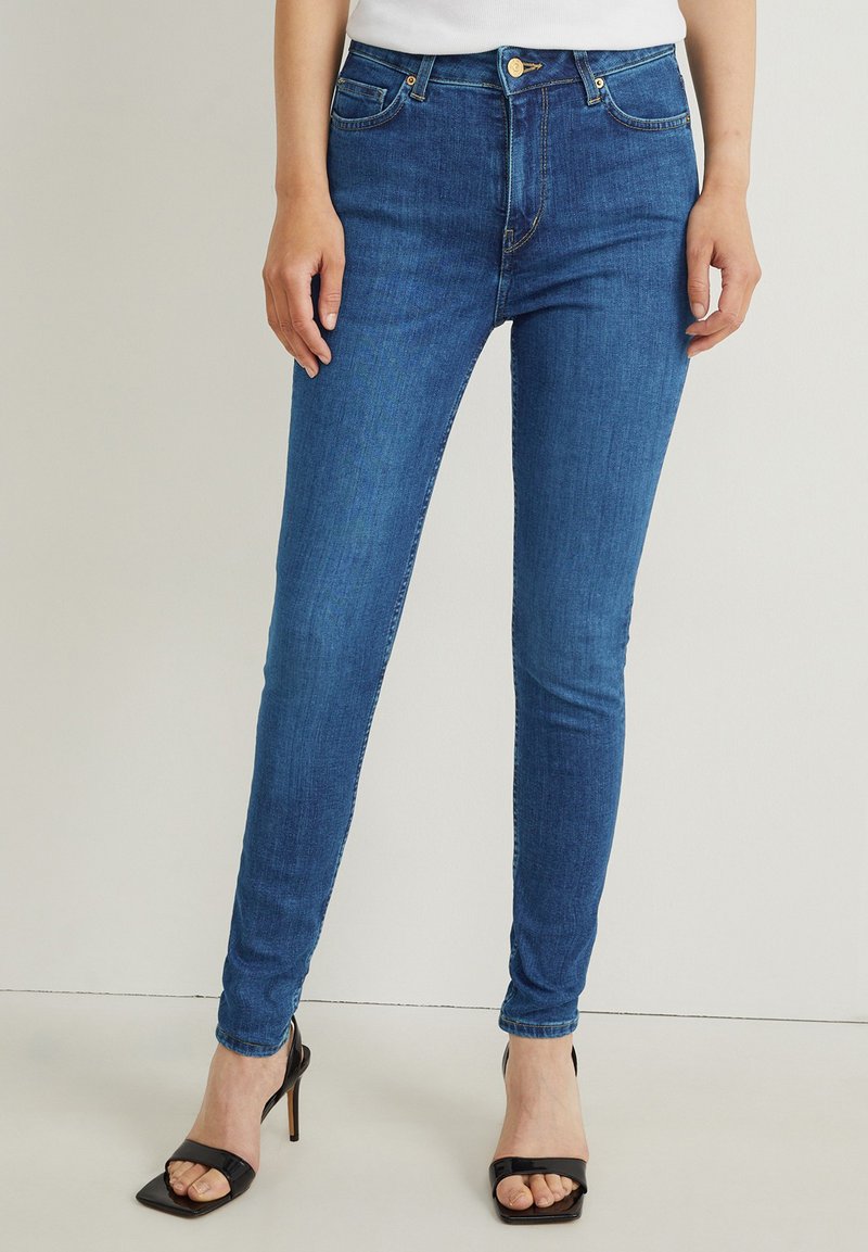 Schmale Jeans aus Denim mit glatter Textur. Verfügen über eine mittlere Leibhöhe, ein Fünf-Taschen-Design und dezente Stickdetails.