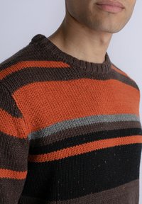 Gebreide trui met oranje, grijze, bruine en zwarte horizontale strepen. Crew neck ontwerp, textuurstof en zichtbaar spikkels overal.
