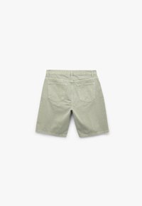 Hellgrüne Baumwollshorts mit klassischem Schnitt, zwei Gesäßtaschen und Steppdetails. Maschinenwaschbarer Stoff mit glatter Textur.