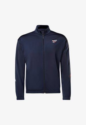 Chaqueta atlética de color azul marino hecha de material ligero, con cremallera frontal completa, cuello alto y logo de Reebok en el pecho.